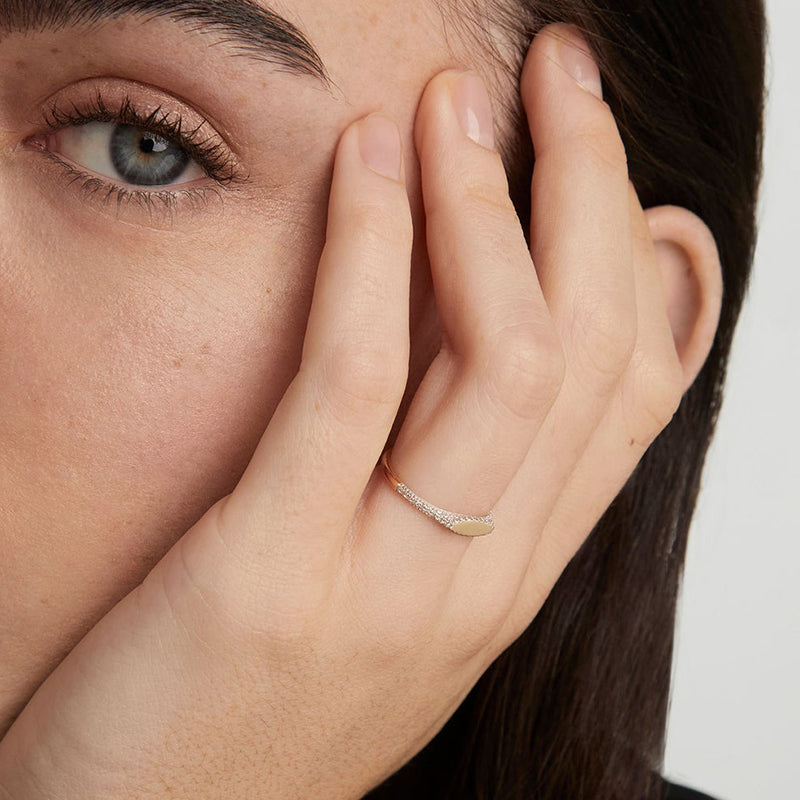 Person wearing Noura ring on hand with part of face showing