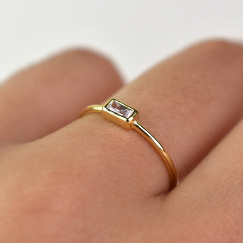 Person wearing Ava ring with finger showing