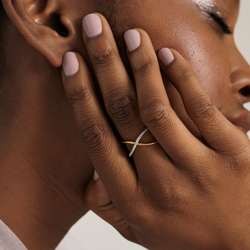 Person wearing Infinity ring with part of hand and face showing