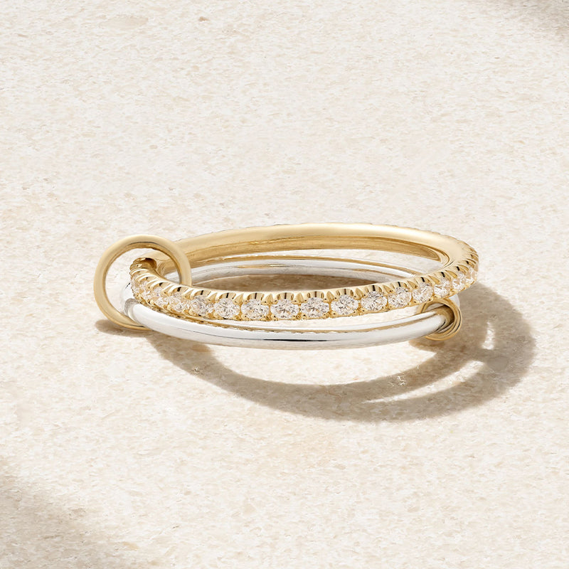 Duo Ring laying down in a fuzy/sandy background