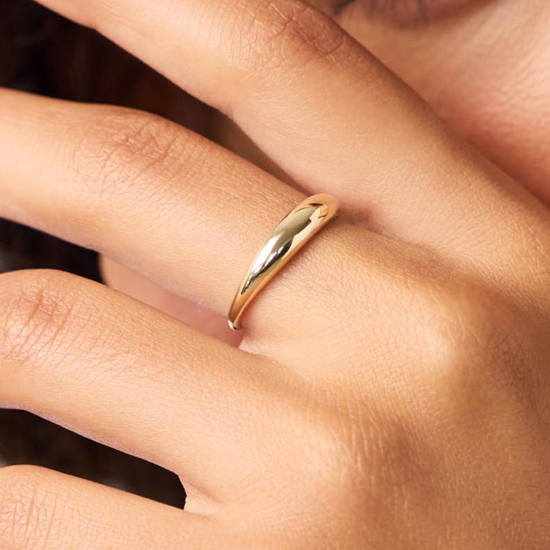 Person wearing Lune ring with close up shot of hand with part of person face in background